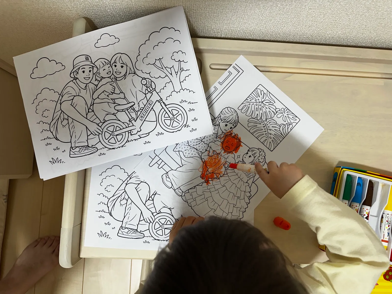 家族写真から作った塗り絵をクレヨンで楽しむ子どもの様子